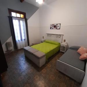 um quarto com 2 camas e um edredão verde em OMA- Casa Temporaria em Capilla del Monte