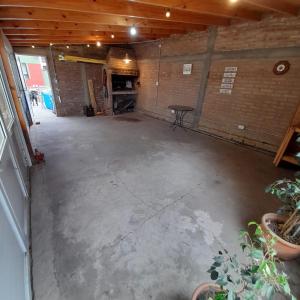uma garagem vazia com piso de betão e uma mesa em OMA- Casa Temporaria em Capilla del Monte