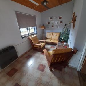 sala de estar con sofá y TV en OMA- Casa Temporaria en Capilla del Monte