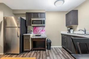 una cocina con electrodomésticos de acero inoxidable y armarios de madera en Exquisite Sublevel Retreat in Van West, en Vancouver