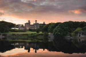 un château avec un lac en face dans l'établissement 19a Francis Street, à Stornoway