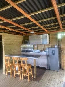 uma cozinha com um bar com cadeiras e um frigorífico em Hospedaje Rural POTOSI em El Peñol