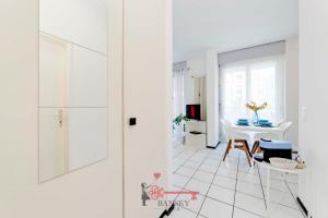 Cette chambre blanche dispose d'une table blanche et d'un sol blanc. dans l'établissement Lime Splendido x4PAX Lugano City, à Lugano