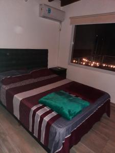 Un dormitorio con 2 camas y una ventana con luces. en Los Altos Apparts en Villa Carlos Paz