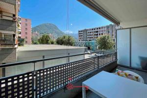 a balcony with a table and a view of a mountain at Lime Splendido x4PAX Lugano City -By EasyLife Swiss in Lugano