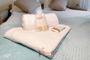 - un lit avec des serviettes et une bouteille dans l'établissement Lime Splendido x4PAX Lugano City, à Lugano