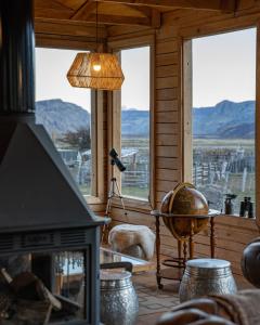 a living room with a fireplace and a view of the mountains at Estancia Bonanza Patagonian Lodge Experience in El Chalten +79 photos