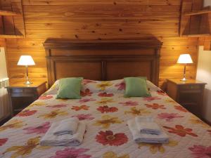 1 dormitorio con 1 cama con 2 toallas en Hosteria Lekun Lekun en Villa La Angostura