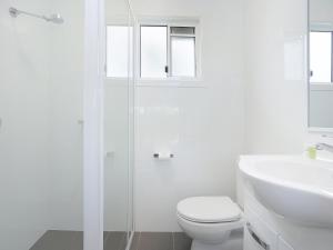 Baño blanco con aseo y lavamanos en NRMA Blue Dolphin Yamba Holiday Resort en Yamba