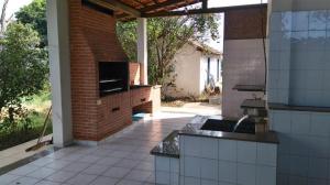 an outdoor kitchen with a brick wall and a patio at Retiro das Águas Araxá in Araxá