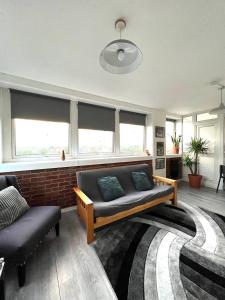 a living room with a couch and a chair at Amazing view 2 bedroom in Abbey Road in London