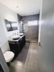 een badkamer met 2 wastafels, een toilet en een douche bij GuestHouse dos Limites in Espinho