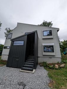 una casa con una puerta negra y una escalera en Hooting Owl private ski chalet en Niseko