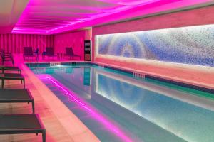 a swimming pool in a building with pink lighting at Courtyard by Marriott Buffalo Downtown/Canalside in Buffalo