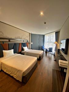 Habitación de hotel con 2 camas y TV de pantalla plana. en KS apec mandala Mũi Né - Bao Ăn sáng KS en Ấp Thiẹn Ái