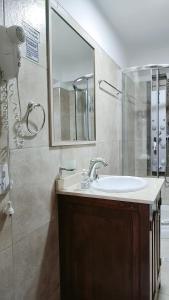 a bathroom with a sink and a mirror at Los Tres Lapachos "Orange" in Salta