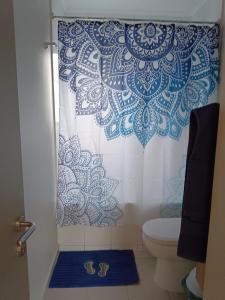 a bathroom with a shower with a blue and white shower curtain at Hermoso departamento nuevo en Pucon equipado con 3 dormitorios wifi y estacionamiento privado a 5 minutos del centro y lago in Pucón