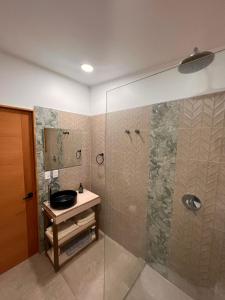 y baño con ducha, lavabo y espejo. en Casa clara San Alfonso en San Alfonso