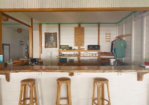 un bar avec deux tabourets dans une pièce avec un comptoir dans l'établissement Katiet Beach Resort Mentawai Lances Right HTS, à Katiet