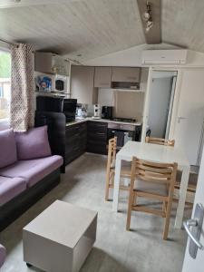 uma cozinha e sala de estar com uma mesa e um sofá em Camping Carabasse Vias plage. em Vias