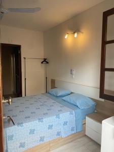a bedroom with a bed with blue pillows on it at Katila-Rooms in Santa Maria