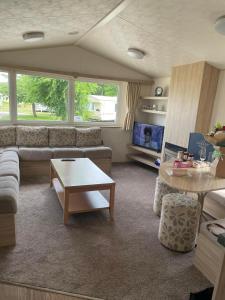 uma sala de estar com um sofá e uma mesa em Parkdean Static caravan on cherry tree holiday park em Great Yarmouth