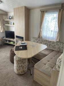 uma sala de estar com uma mesa e um sofá em Parkdean Static caravan on cherry tree holiday park em Great Yarmouth