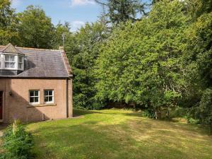 an old brick house with a yard and trees at South Lodge in Banchory