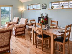 - une salle à manger avec une table et des chaises en bois dans l'établissement Cedar Lodge, à Old Buckenham