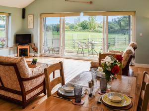 ein Wohnzimmer mit einem Tisch und Stühlen sowie ein Esszimmer in der Unterkunft Cedar Lodge in Old Buckenham