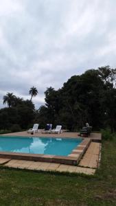 a swimming pool with two lounge chairs next to it at Retiro das Águas Araxá in Araxá