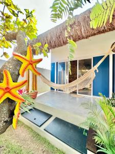 two starfish hanging from a hammock in front of a house at Noah Hostel & Chale in São Miguel do Gostoso