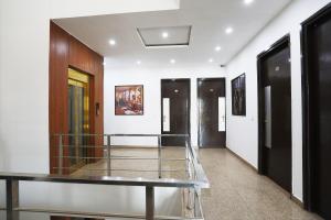 a hallway with black doors and white walls at Super Tipsyy Inn 014 in Gurgaon