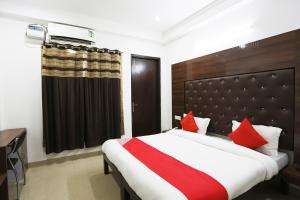 a bedroom with a large bed with red pillows at Super Tipsyy Inn 014 in Gurgaon