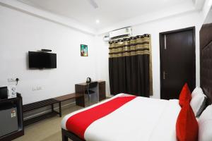 a hotel room with a bed and a television at Super Tipsyy Inn 014 in Gurgaon
