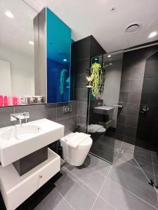 La salle de bains est pourvue d'un lavabo blanc et de toilettes. dans l'établissement WSP Spencer St Premium Luxury, à Melbourne