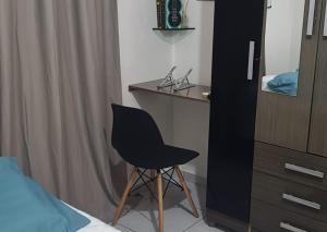 Schlafzimmer mit einem schwarzen Stuhl und einem Schreibtisch in der Unterkunft Apê Térreo, próximo ao Shopping! in Petrolina