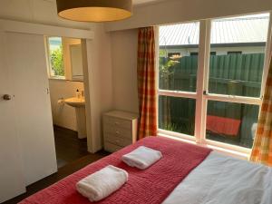um quarto com uma cama com duas toalhas em HPG Villa formerly known as Pipi Hotel em Havelock North
