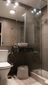 La salle de bains est pourvue d'un lavabo et d'une douche en verre. dans l'établissement Obelisco 1, à Buenos Aires