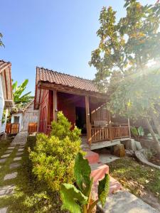 una piccola casa rossa con un portico in un cortile di Villa Bangunjiwo a Ngingas