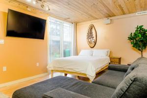 a bedroom with a bed and a tv and a couch at Portland Urban Lodge, Quiet, Walkable, Near in Portland
