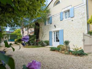 a house with blue doors and a gravel yard at Gîte au bord de la Charente avec jardin privatif, wifi fibre, vélos et équipements familiaux - FR-1-653-162 in Saint-Genis-dʼHiersac