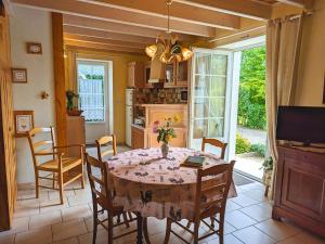 a kitchen and dining room with a table and chairs at Gîte au bord de la Charente avec jardin privatif, wifi fibre, vélos et équipements familiaux - FR-1-653-162 in Saint-Genis-dʼHiersac