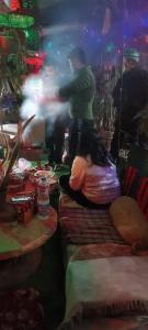 a person sitting on a table in a room with food at Mansarover Home Stay in Kalimpong