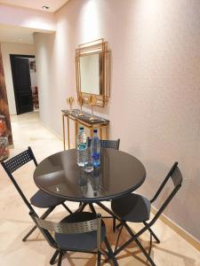 a black table and chairs with water bottles on it at luxury downtown apartment of 80m2 in front of Hassan 2 Mosquē and sea from family , pour famille , INTERDIT COUPLES ARAABIC NON MARIÉ, FORBIDDEN UNMARRIED ARAABIC COUPLES basement car park in Casablanca
