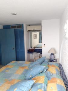 1 dormitorio con 1 cama grande con almohadas azules en Departamento en Acapulco La Palapa, en Acapulco