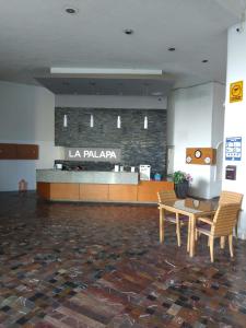 a lobby with a table and a counter in a building at Departamento en Acapulco La Palapa in Acapulco
