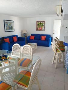 sala de estar con sofá azul y sillas en Departamento en Acapulco La Palapa, en Acapulco