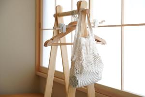 eine Tasche hängt auf einer Holzleiter neben einem Fenster in der Unterkunft RIKKA HANASATO in Takayama