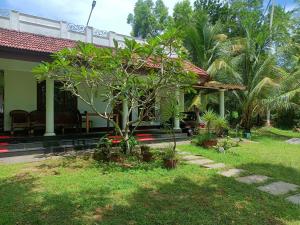 a garden in front of a house with a tree at Angels' homestay Marari in Mararikulam
